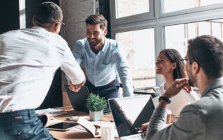 Business people shaking hands signifying a deal with a company owner and a copier leasing company