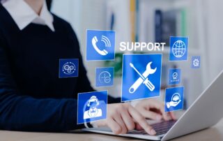 A person types on a laptop with floating digital icons representing tools, customer service, and communication, symbolizing 24/7 professional IT support services in a modern business environment.